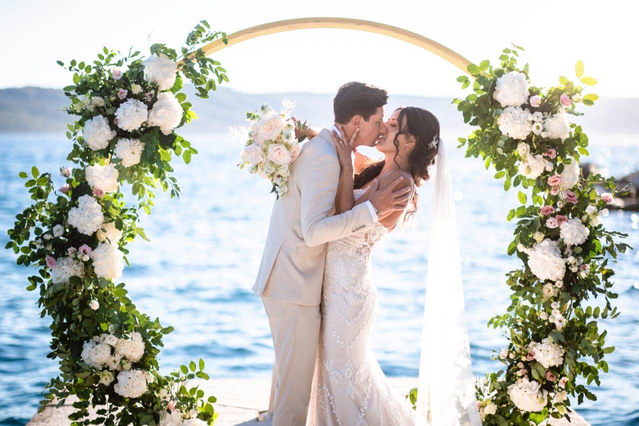 Brautpaar unter Traubogen bei Hochzeit in Kroatien in Dalmatien