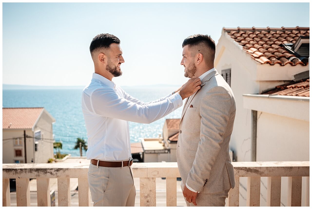 Bräutigam und Freund beim Bräutigam getting ready auf eine Balkon mit de Blick aufs Meer für seine Hochzeit in Kroatien